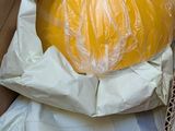 a large yellow pumpkin sitting in a box on a table