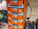 a small orange cabinet with many drawers in the back of it