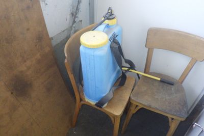 un bac bleu posé sur une chaise en bois à côté d'une chaise marron