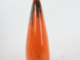 an orange vase that is sitting on a white surface