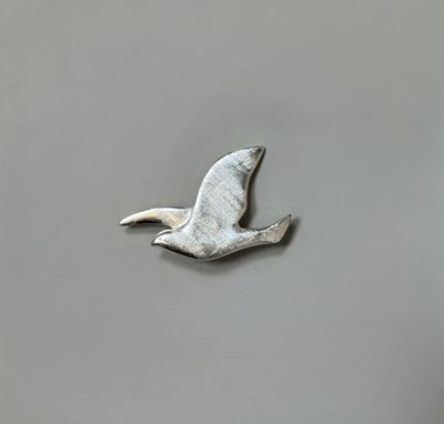 un oiseau argenté qui vole dans le ciel