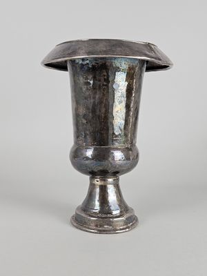 a silver vase that is sitting on a table