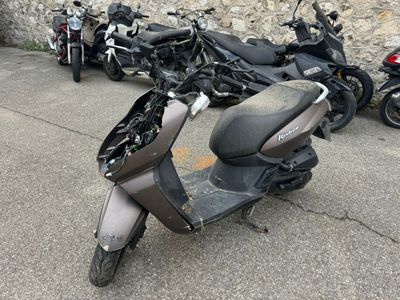 un scooter garé devant un mur de pierre