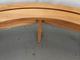 a curved wooden bench with a curved seat on it