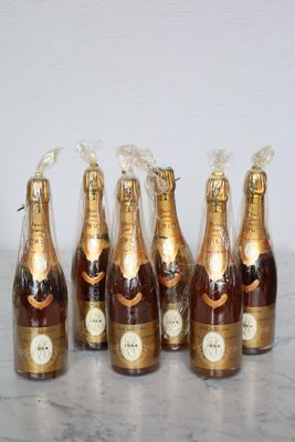 six bottles of champagne are lined up on a marble table