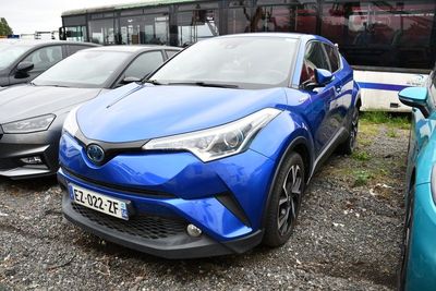 une Toyota C-HR bleue garée devant un bus
