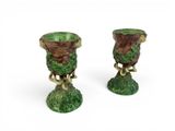 two green vases sitting next to each other on a white surface