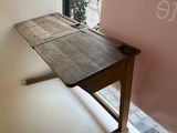 a wooden table in front of a window with a sign on it