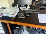 un bureau sur lequel se trouvent un ordinateur, un clavier, une souris et d'autres objets