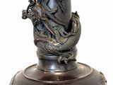 a statue of a dragon on a pedestal with a white background