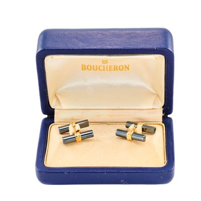 une paire de boutons de manchette dans un coffret bleu sur fond blanc