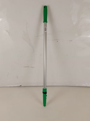 un stylo vert posé sur une table blanche, près d'un mur blanc