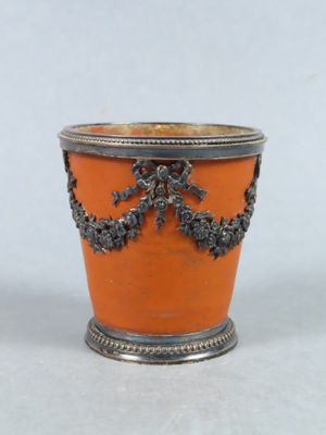 un vase orange orné d'un motif argenté