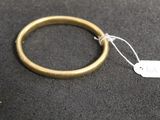 a gold ring with a tag on it on a black surface