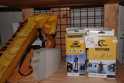 deux boîtes de skis et un sac posés sur une étagère