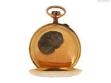 a gold pocket watch with a black face on it