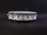 blue and white bowl on a black surface with a black background
