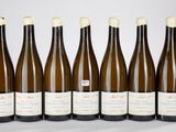 six bouteilles de vin sont alignées sur une table
