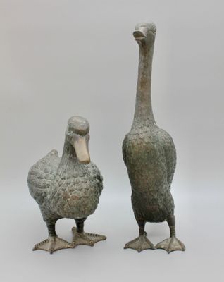 une paire de canards en bronze sur pied, placés côte à côte sur un fond blanc