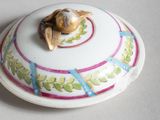a small white bowl with a gold turtle on it