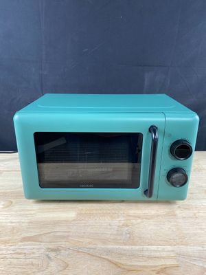 un vieux four à micro-ondes posé sur une table en bois