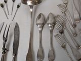 a lot of silver spoons and forks on the table