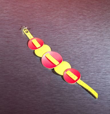 a yellow and red watch on a black surface