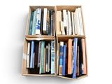de nombreux livres dans une boîte posée sur une surface blanche