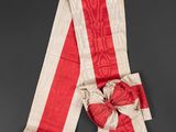 an old red and white striped scarf with a bow on it