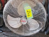 un ventilateur posé par terre à côté d'autres objets