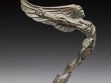une image représentant une sculpture d'un oiseau aux ailes déployées posé sur un socle