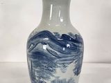un vase bleu et blanc posé sur une surface blanche