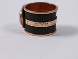 an image of a black and gold ring with a name engraved on it
