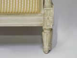 a white chair with a striped seat and a wooden foot rest