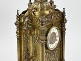 a gold clock sitting on top of a white table
