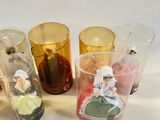 five different colored glass cups with figurines in them