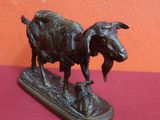 bronze statue of a goat and a dog on a wooden base