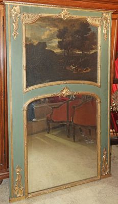 un grand miroir posé par terre à côté d'une chaise