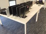 three computer screens on the desk in the office