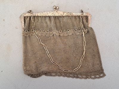 an old purse with a chain hanging from it ' s side