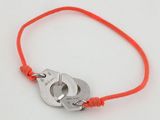 un bracelet en fil rouge orné de deux menottes