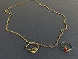 un ensemble composé d'un collier et d'une bague en or, sertis d'une pierre rouge