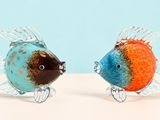 two fish figurines that are sitting on a table