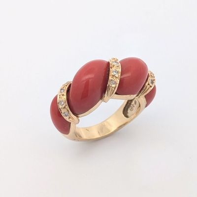 l'image d'une bague rouge et dorée sur un fond blanc