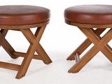 pair of wooden stools with brown leather seats on a white background