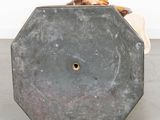 concrete sculpture of a man sitting on top of a chair