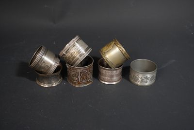 six silver and gold napkins on a black surface