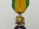 a gold medal with a blue and green ribbon around it