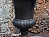 a black urn sitting in front of a stone wall