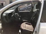 the interior of a small car with the door open and the driver ' s seat down